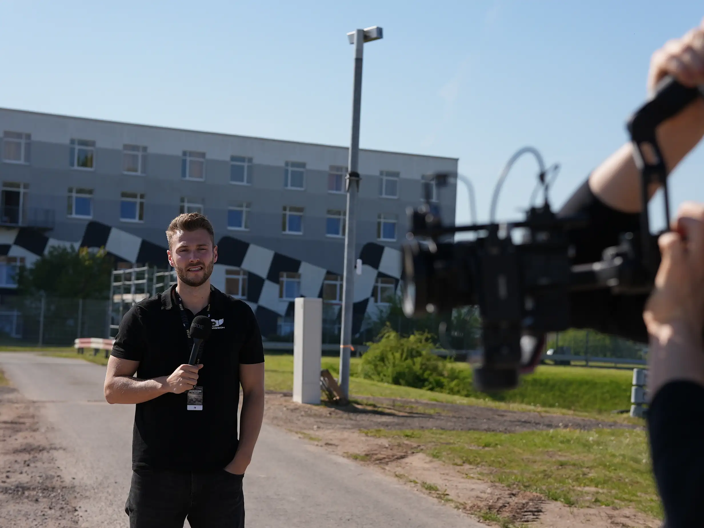 Nick Großmann von Skypassion beim Interview vor der Kamera auf einer Rennstrecke – Behind the Scenes Videoproduktion