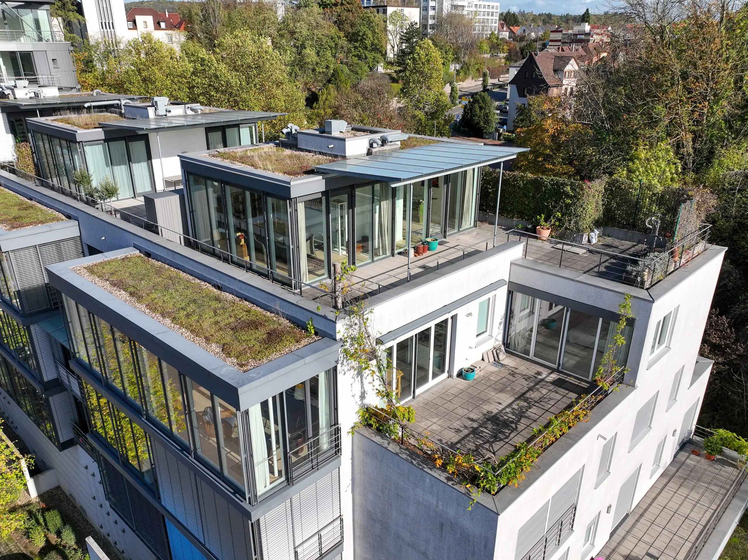 Drohnenaufnahme moderner Mehrfamilienhäuser mit Dachterrassen und Glasfronten – professionelle Immobilienaufnahmen von Skypassion Baden-Württemberg